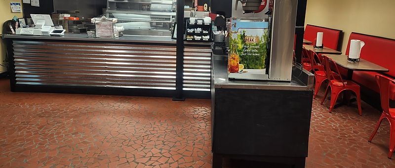 The order counter and dining area inside The Shack, with red booths and chairs